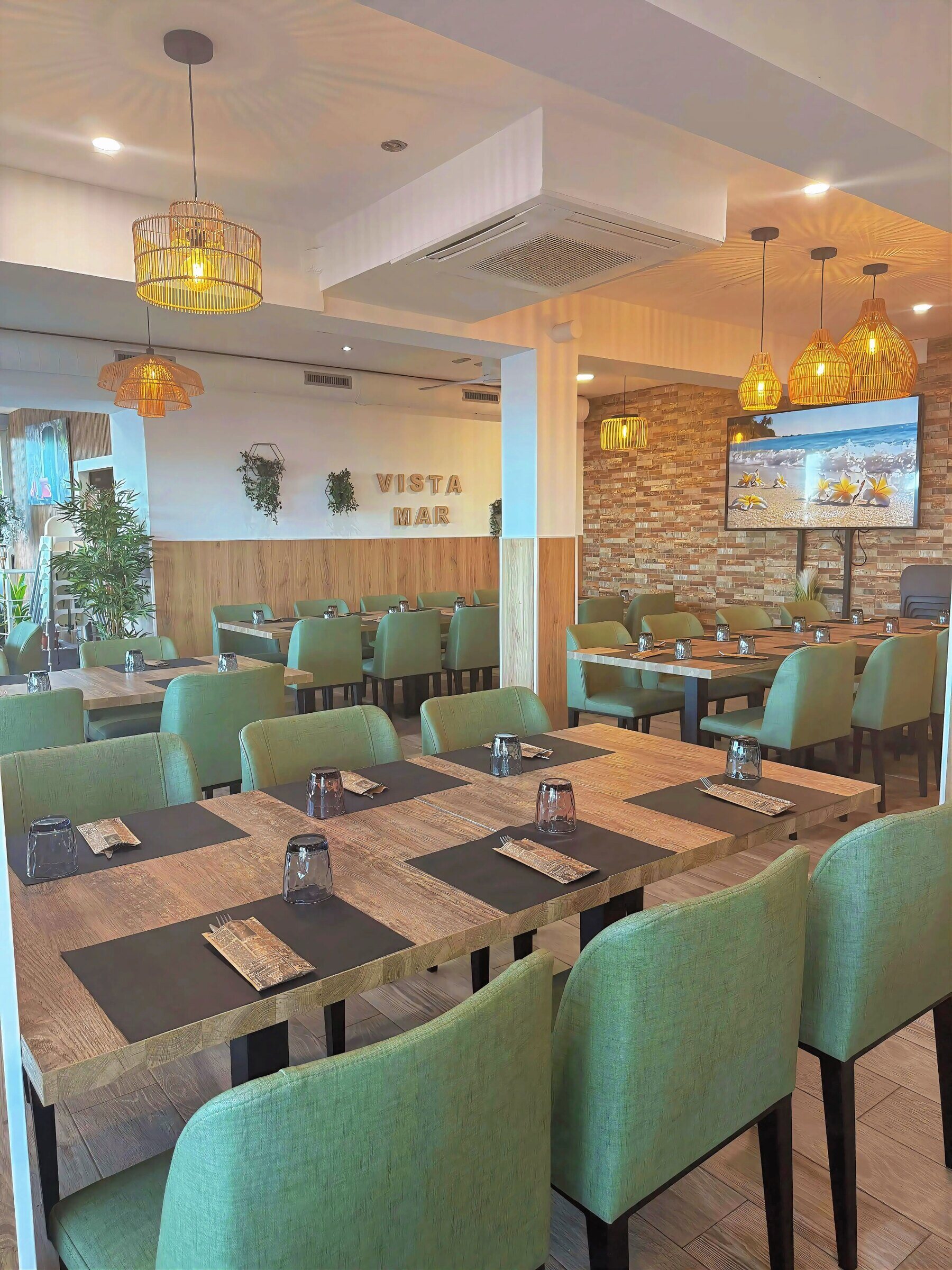 Comedor interior con mesas de madera y sillas verdes