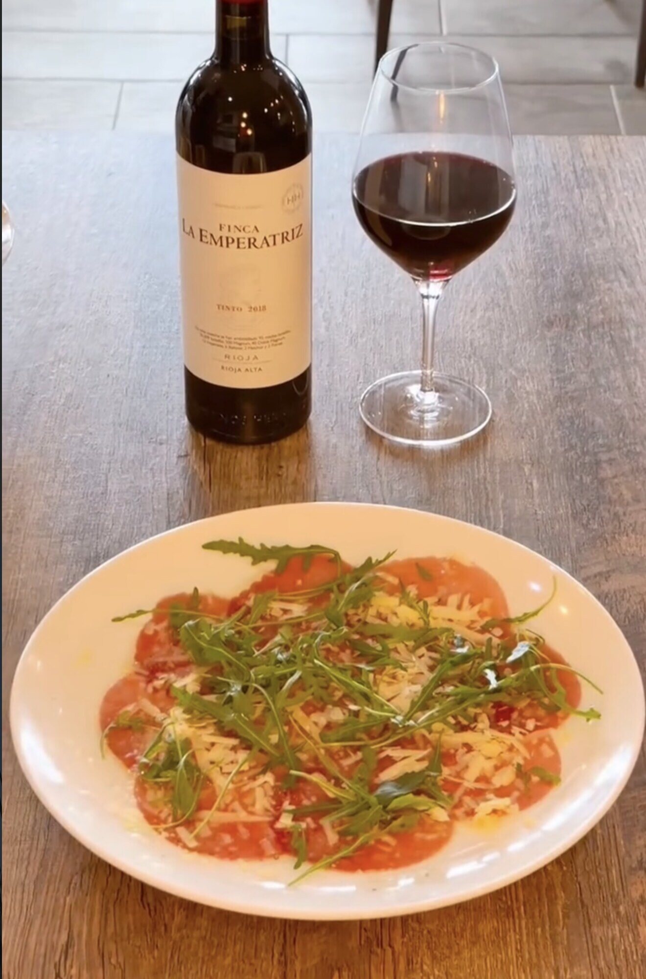 Carpaccio de ternera con rúcula y parmesano, con una copa de Finca La Emperatriz